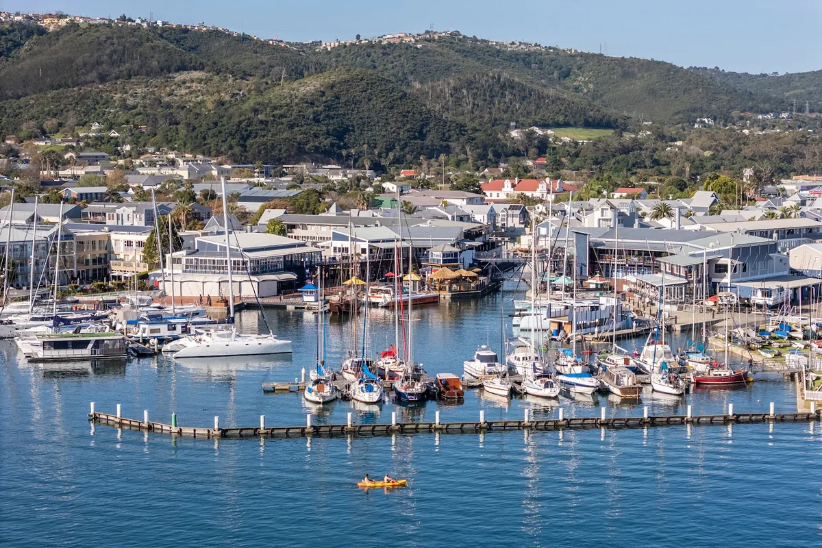 Aerial of Knysna Waterfront marina with the town and forested hills behind, Western Cape