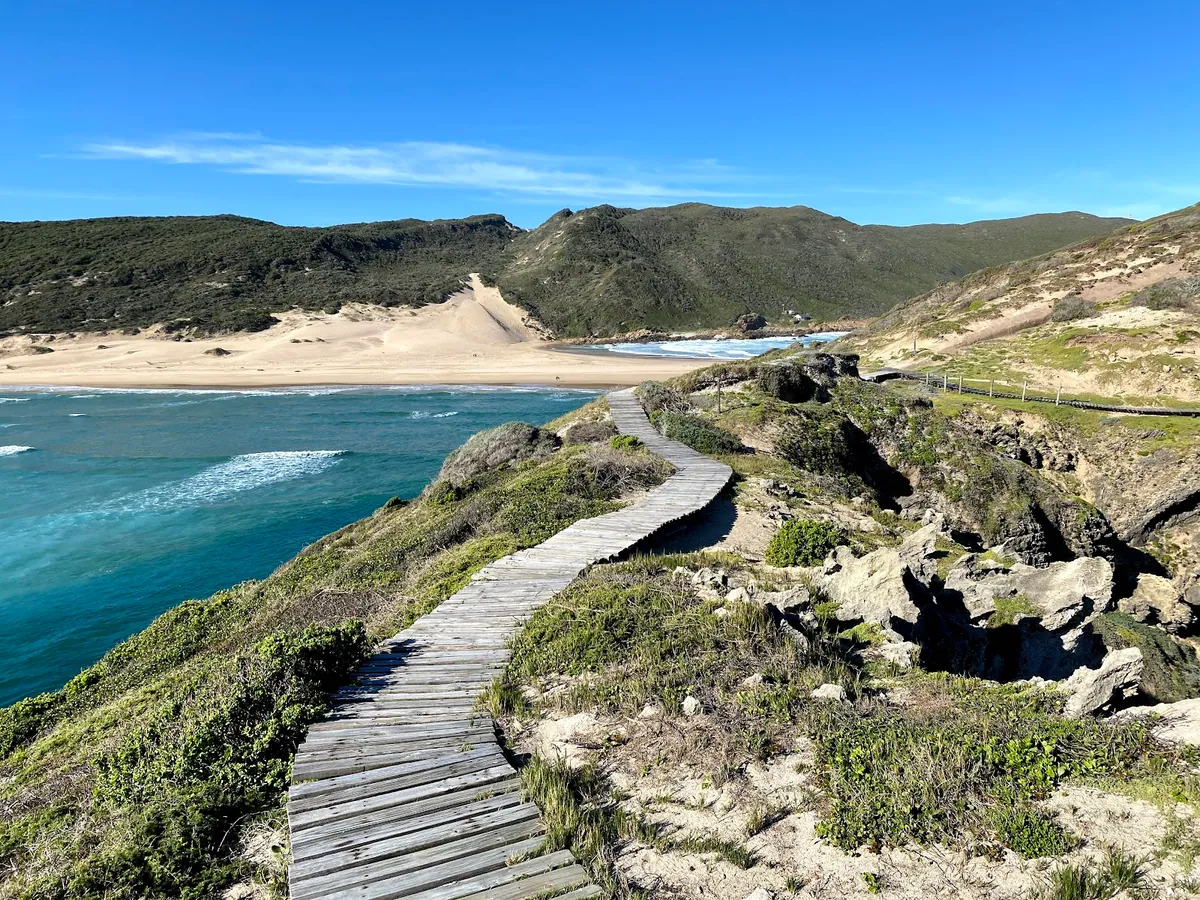 Robberg Nature Reserve — wooden walkway above a sandy cove inside the peninsula south of Plettenberg Bay