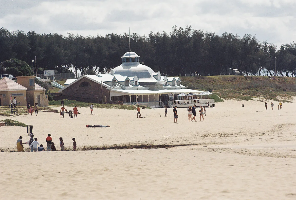 Santos Beach at Mossel Bay — wide sand with swimmers and the domed Santos Pavilion behind