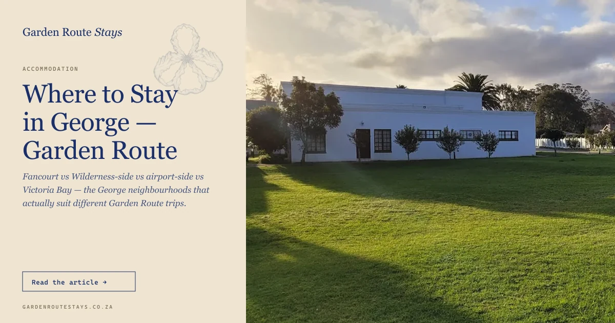White Cape-Dutch estate building on a manicured lawn at Fancourt, George, with Outeniqua mountains rising behind under dramatic cloud