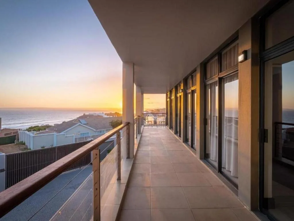 Expansive covered deck with ocean and sunset views at golden hour