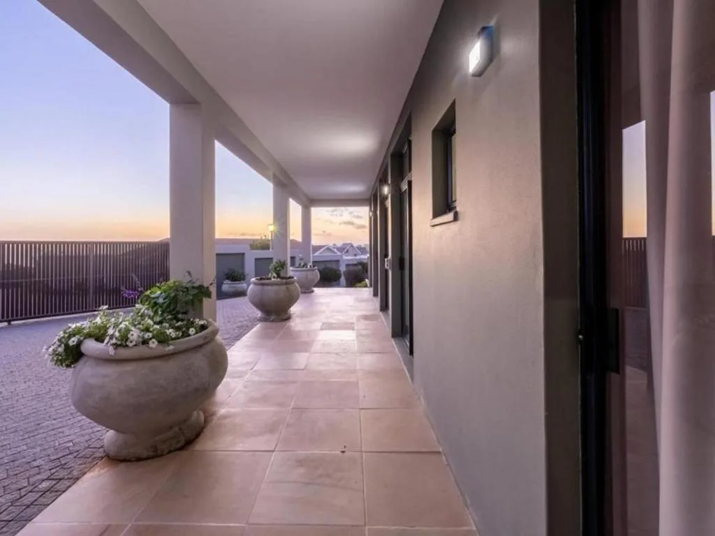 Covered patio with potted plants and mountain views at sunset