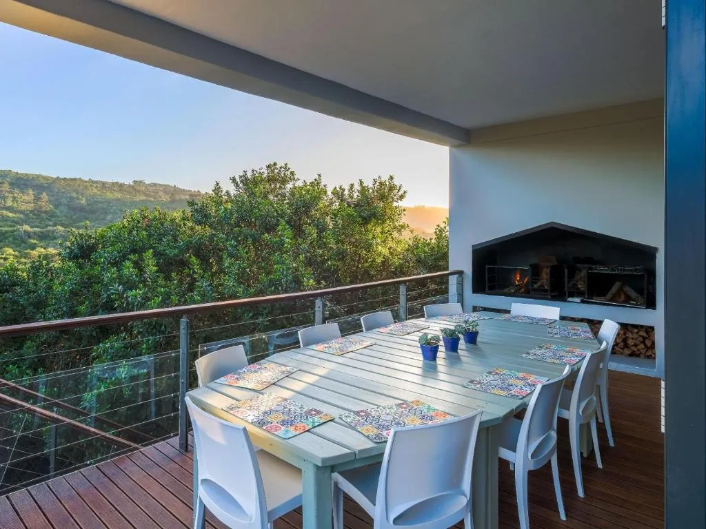 Outdoor dining deck with table, chairs, fireplace, and mountain views