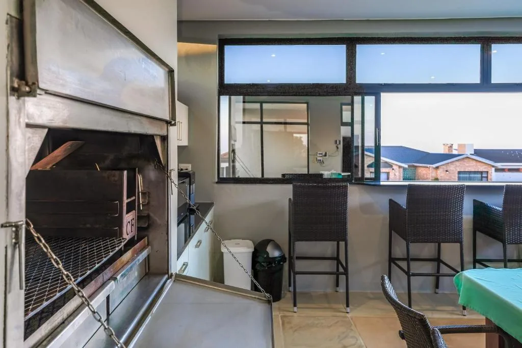Outdoor deck with braai grill, bar seating, and town views