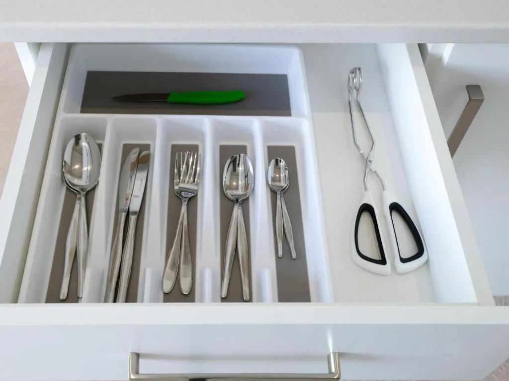 Open kitchen drawer with organized silverware and utensils neatly arranged