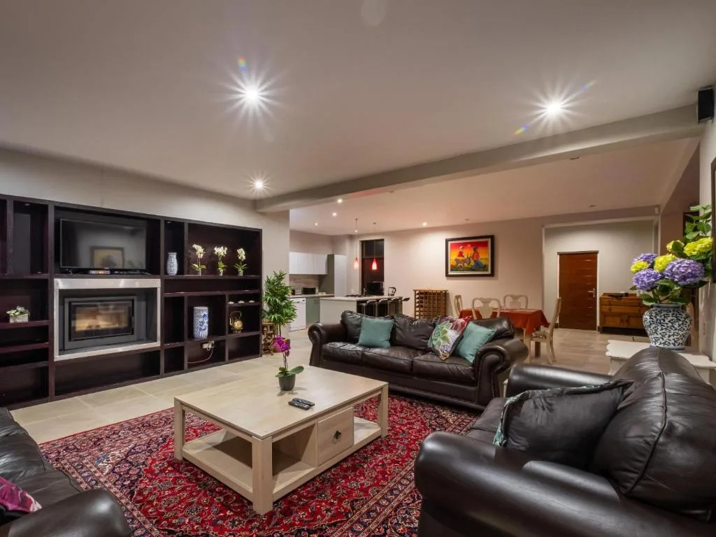Spacious lounge with leather sofas, fireplace, and modern lighting fixtures