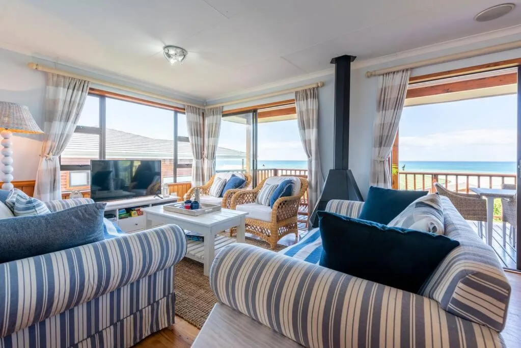 Spacious beachfront lounge with striped sofas and ocean views