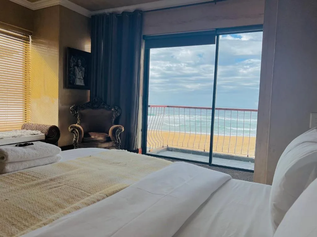 Spacious beachfront bedroom with ocean view through sliding glass doors