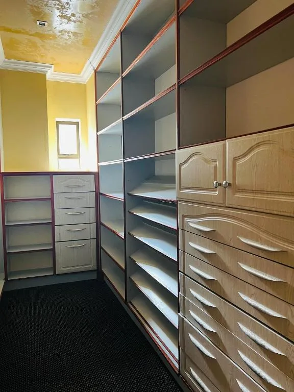 Built-in wardrobe and storage with mirrored doors and wooden cabinetry
