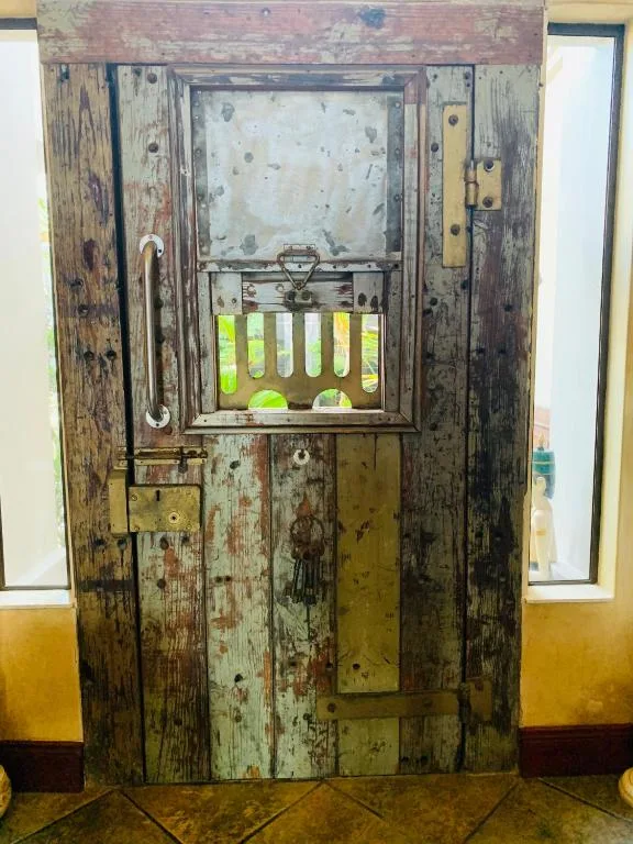 Rustic wooden door with peeling paint and decorative window panel