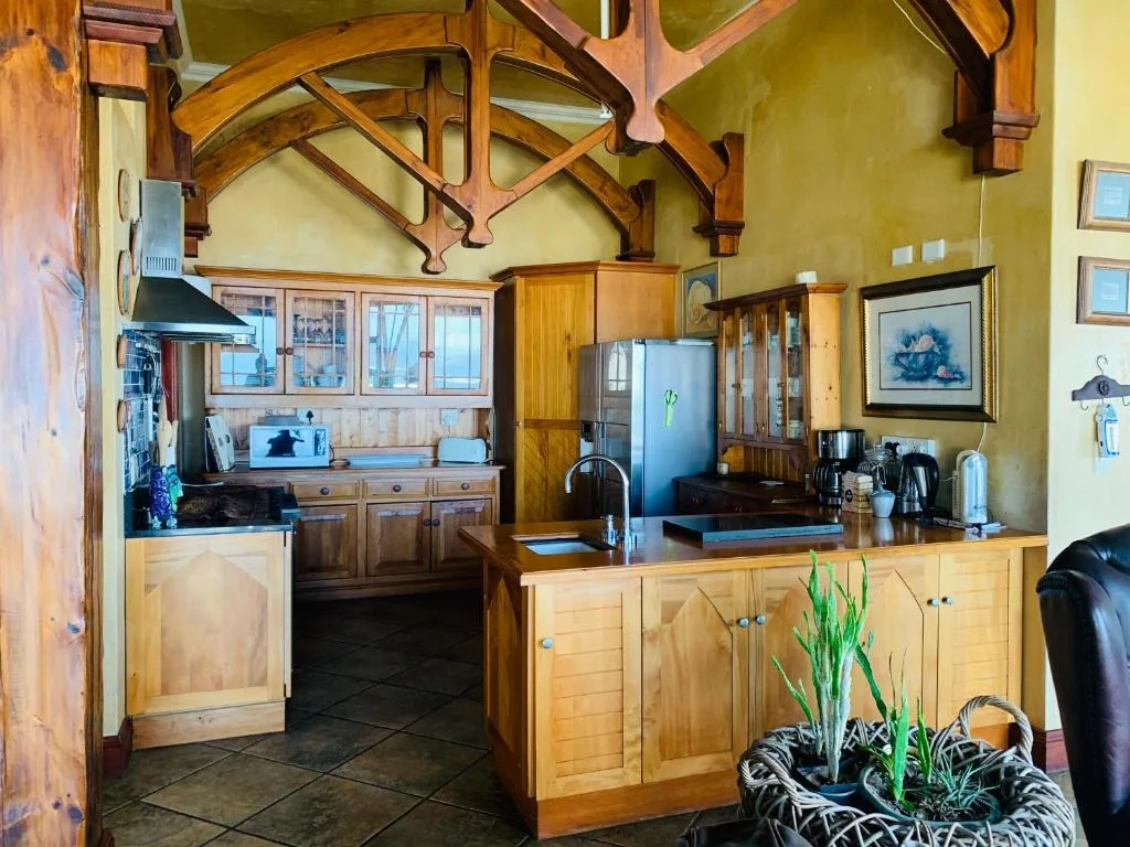 Spacious kitchen with wooden cabinetry, exposed beams, and modern stainless steel appliances