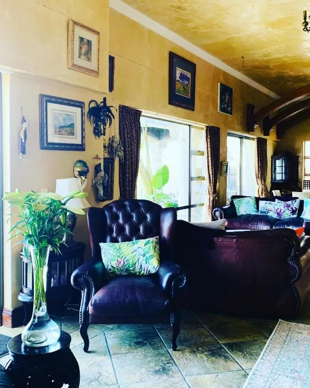 Bright yellow lounge with black leather armchairs and large glass doors