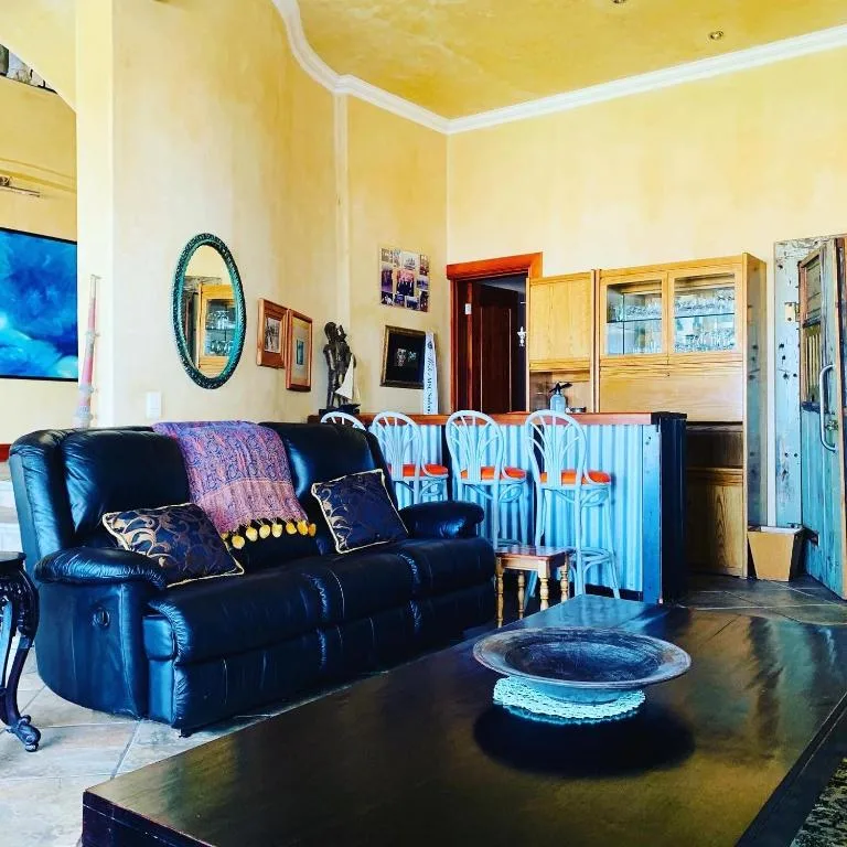 Bright yellow lounge with blue leather sofa and coastal decor accents