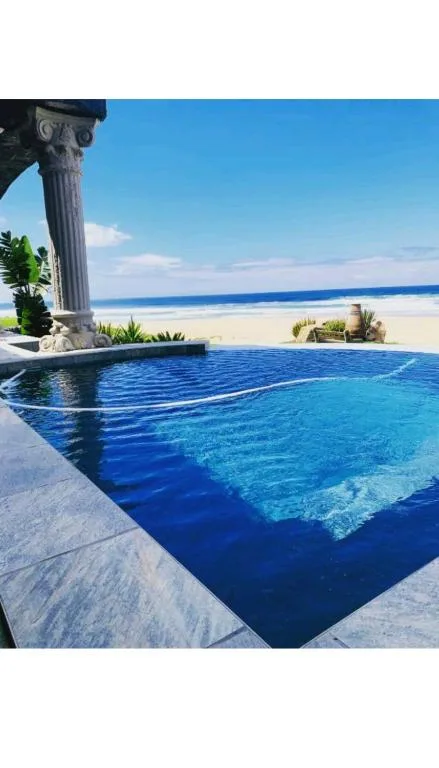 Infinity pool overlooking pristine beach and ocean horizon