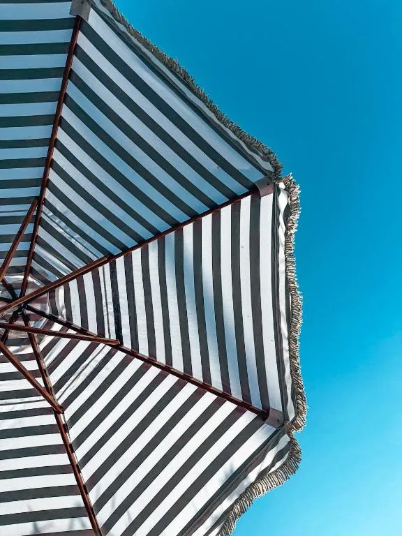 Striped awning canopy against clear blue sky providing outdoor shade