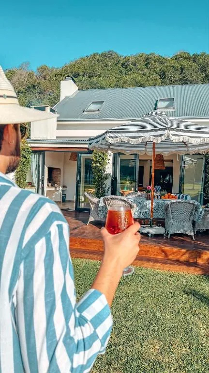 Striped awning shades wooden deck with outdoor seating and refreshments