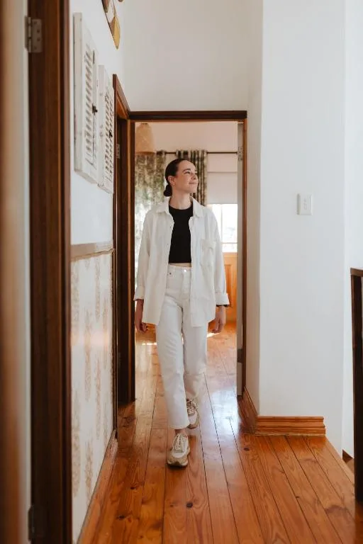 Hallway with wooden floors and warm lighting, leading through interior rooms