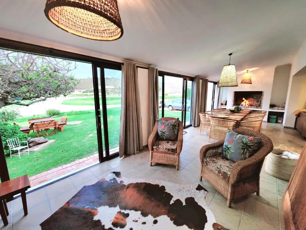 Spacious lounge with wicker chairs, fireplace, and garden views