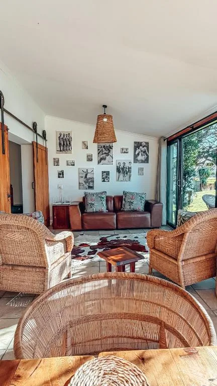 Spacious lounge with woven chairs, burgundy sofa, and photo gallery wall