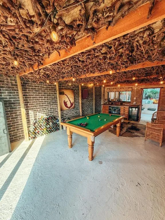 Recreation room with pool table, brick walls, and wooden beam ceiling