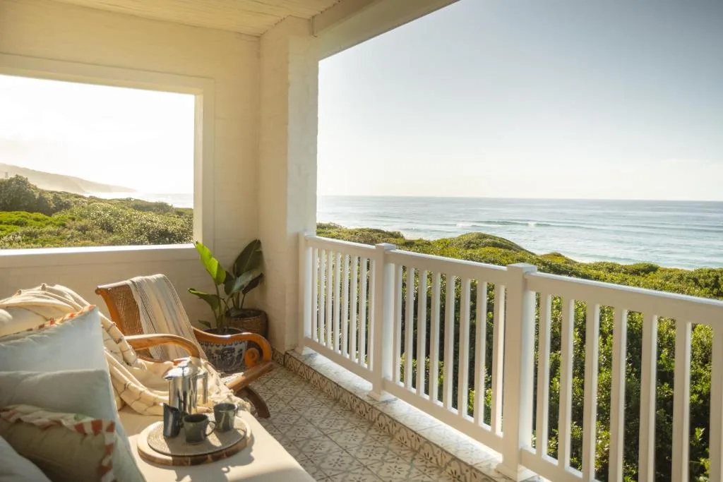 Oceanview deck with comfortable seating and white railings overlooking dunes
