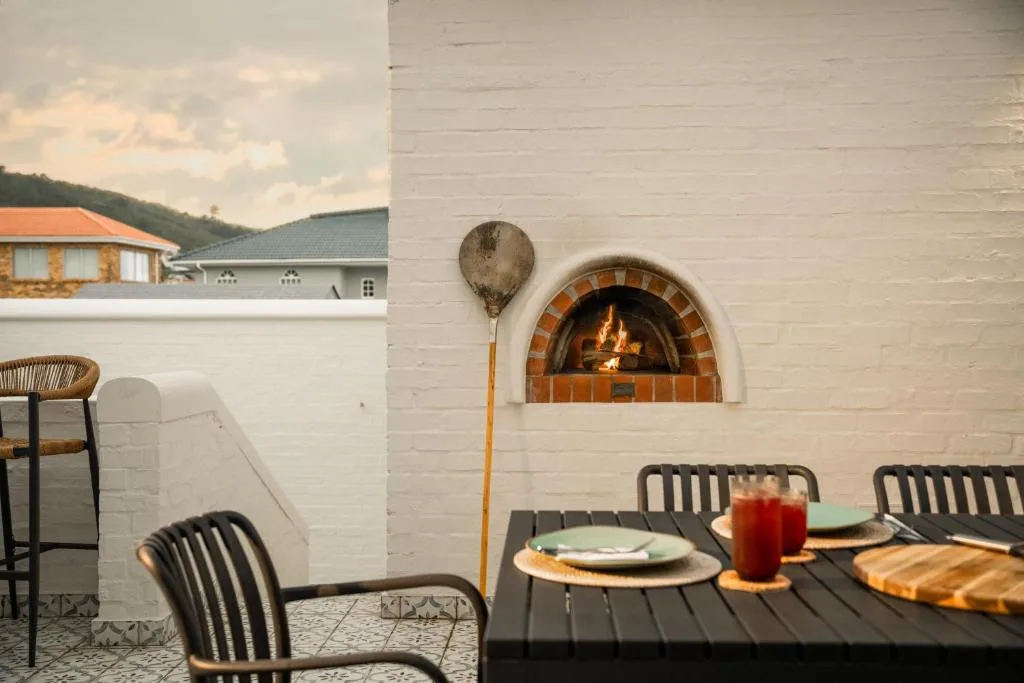 Outdoor dining area with fireplace, table settings, and mountain views