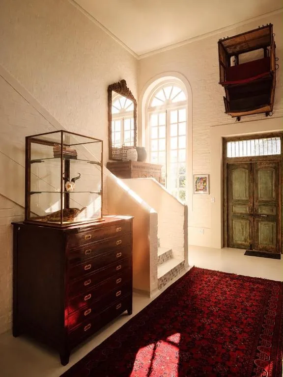 Vintage wooden dresser and glass cabinet in sunlit hallway entrance