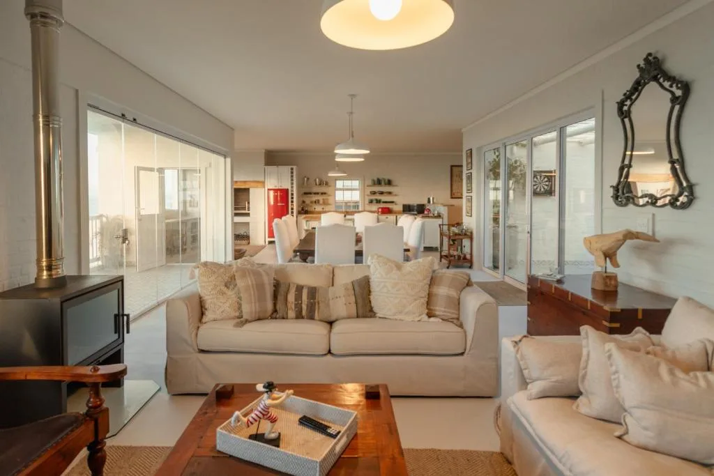 Spacious living room with beige sofas, wooden table, and open-plan layout