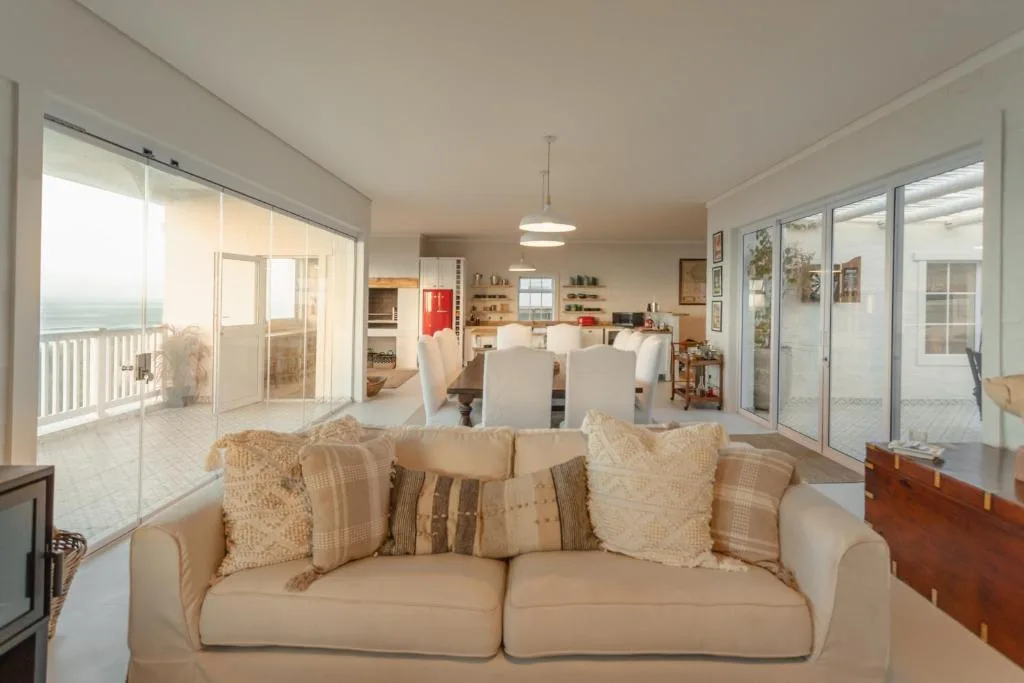Spacious open-plan lounge with cream sofa, ocean view, and dining area beyond