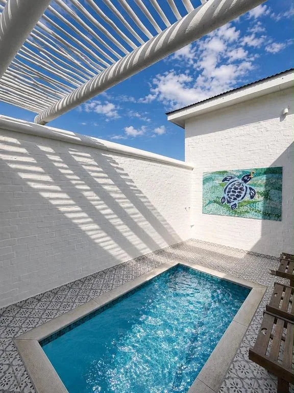 Inviting small pool with turquoise water and retractable pergola shade