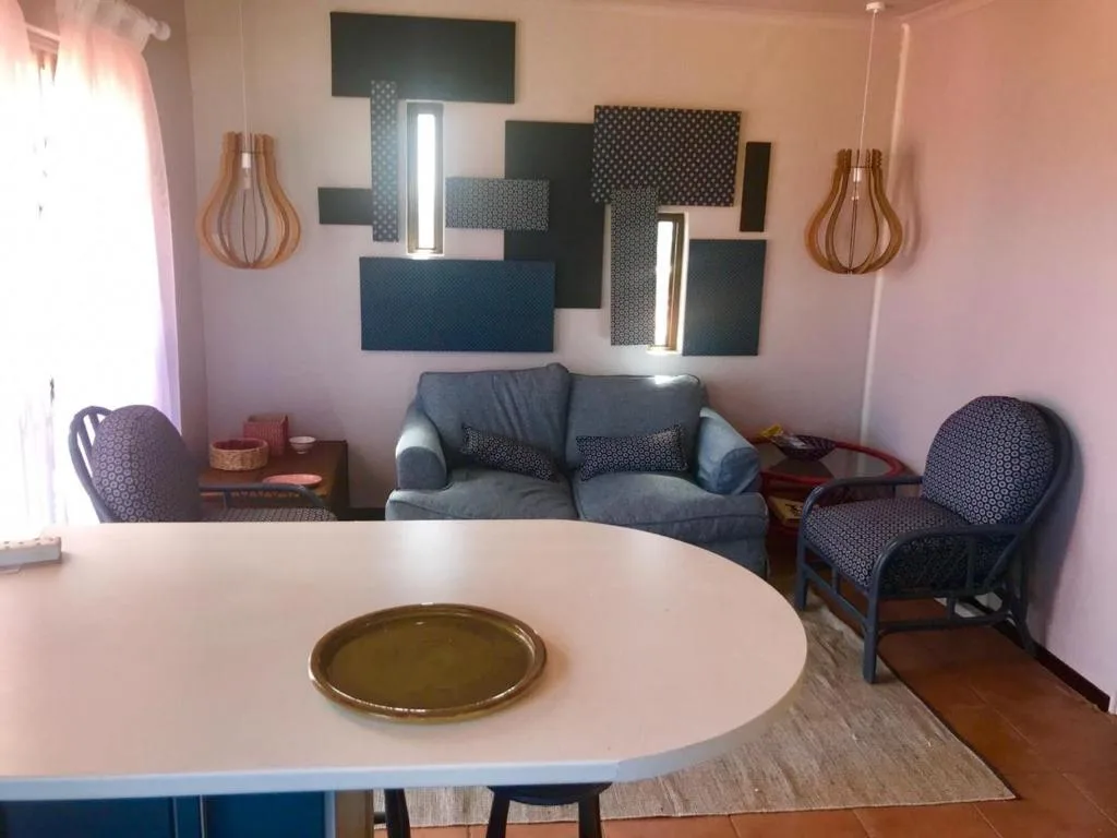 Open-plan lounge with gray sofa, accent chairs, and round dining table