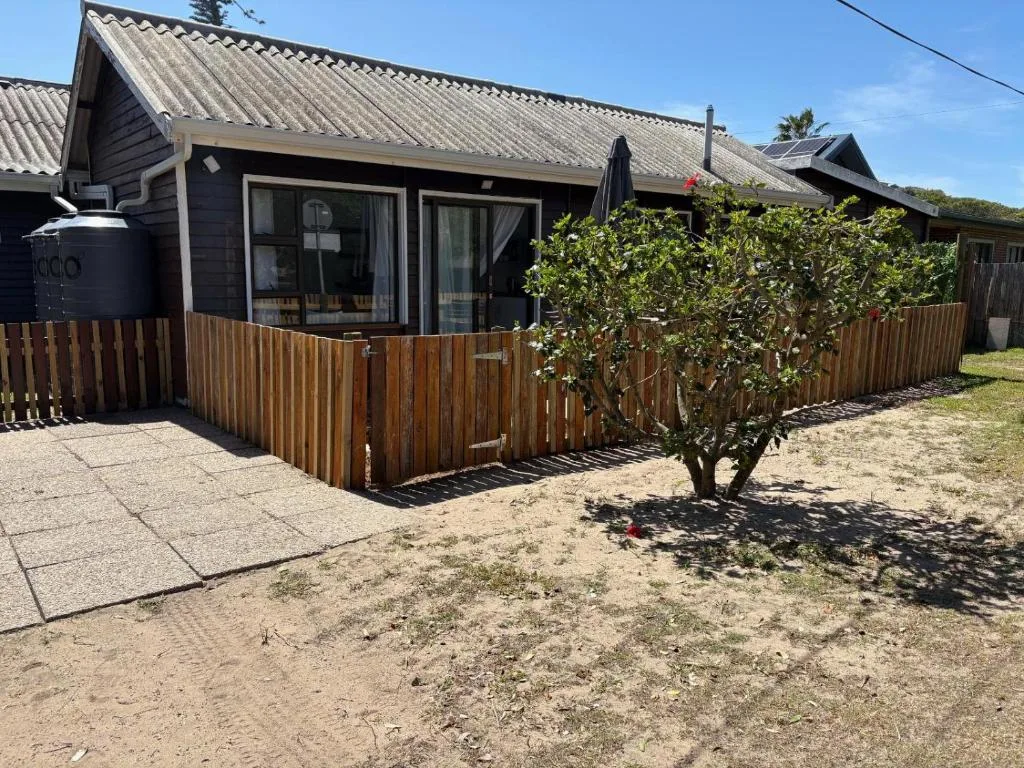 Modern cottage with corrugated metal roof and wooden deck fencing