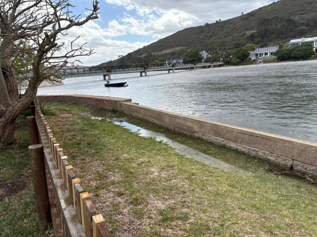 Scenic lagoon view with mountains, jetty, and waterfront properties visible