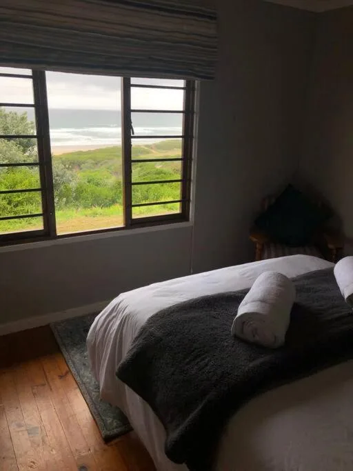 Bedroom with ocean and coastal landscape view through large windows