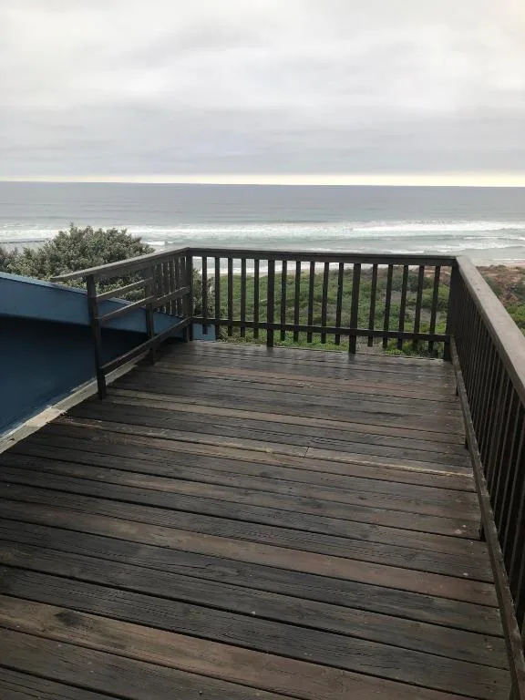 Wooden deck with ocean and beach views from the property railing
