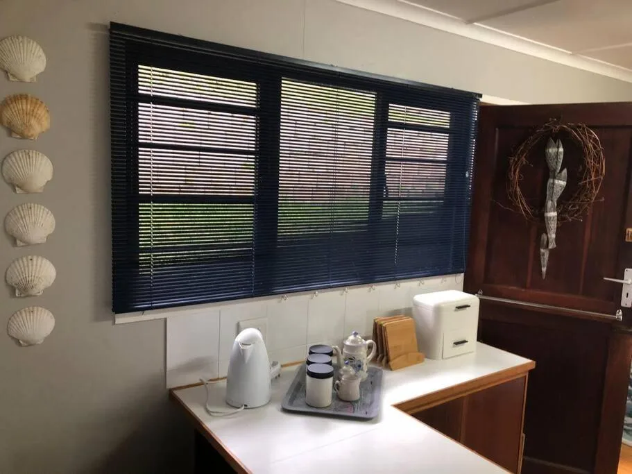 Close-up of hospitality amenities on bedroom counter with kettle and accessories