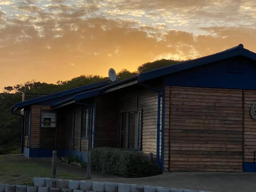 Modern wooden cabin with blue trim at golden hour sunset
