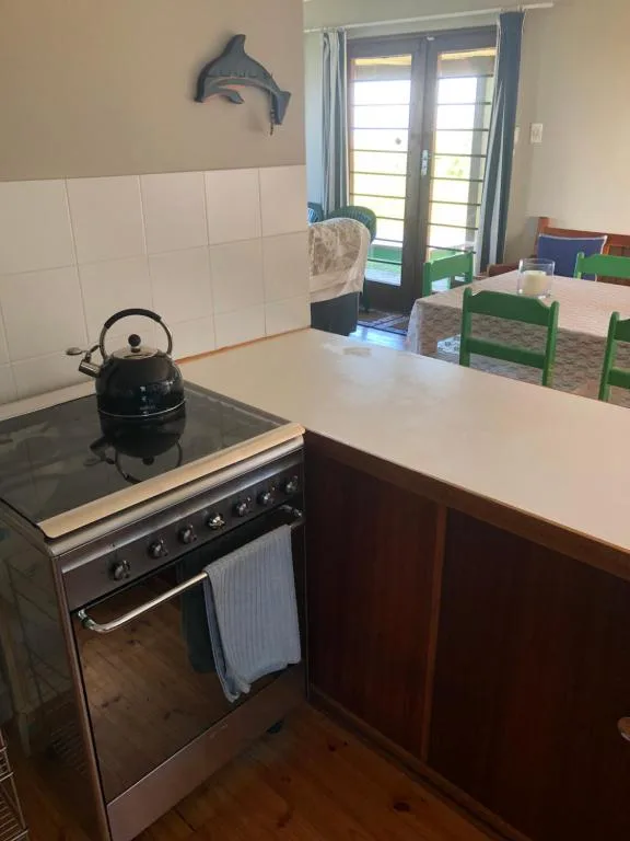 Kitchen with stove, countertop, and white tile backsplash