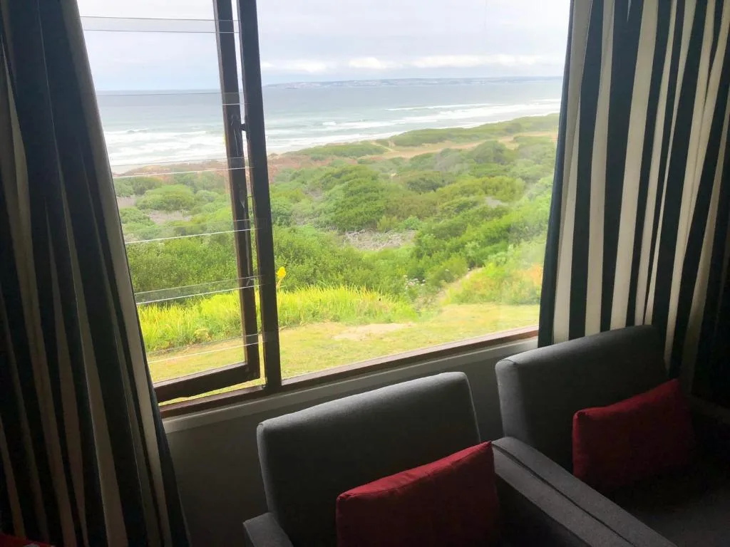 Ocean and coastline vista through large window with seating