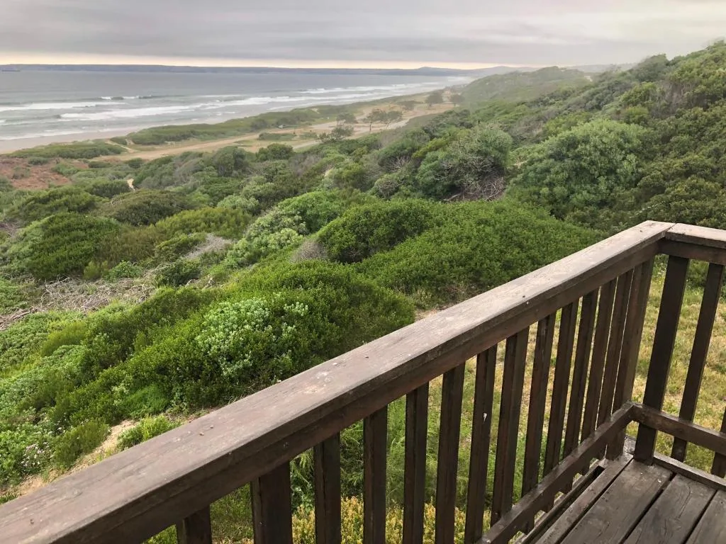 Expansive coastal view from deck railing overlooking lagoon and sandy beach