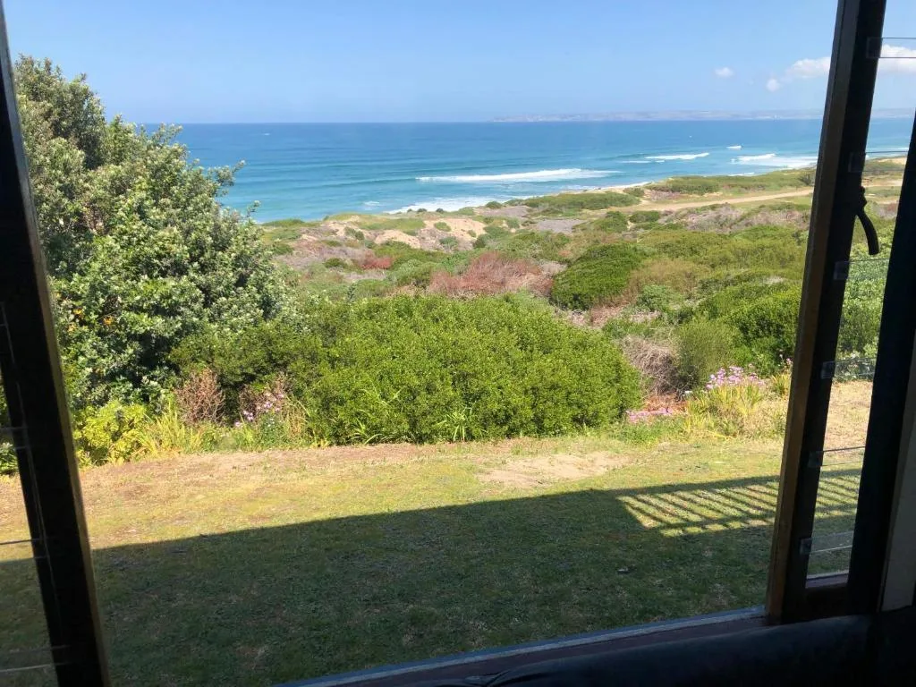 Panoramic ocean and coastline view from property with lush green vegetation below