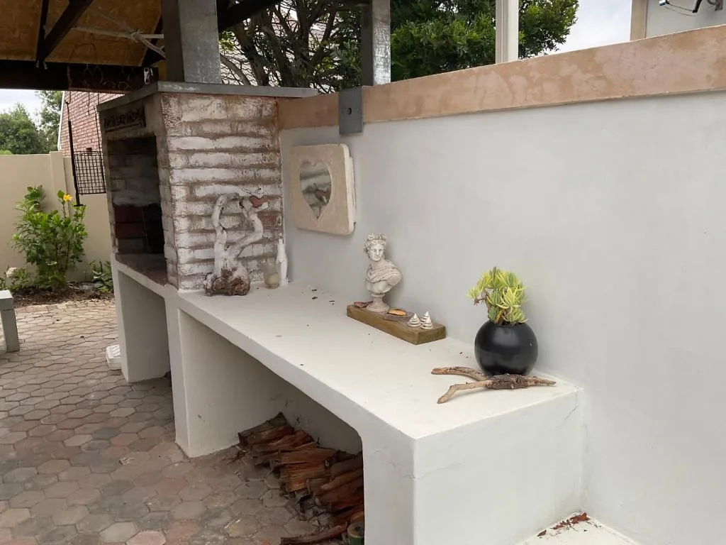 Outdoor decorative shelf with sculptures, plants, and rustic wood accents