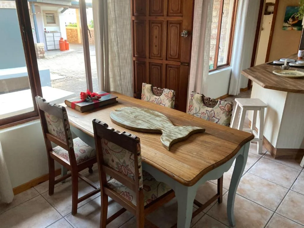 Wooden dining table with patterned chairs and ocean view access