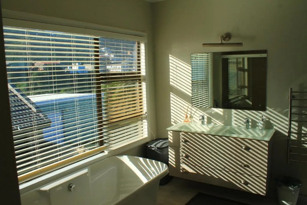 Modern bathroom with double vanity and ocean view through large windows