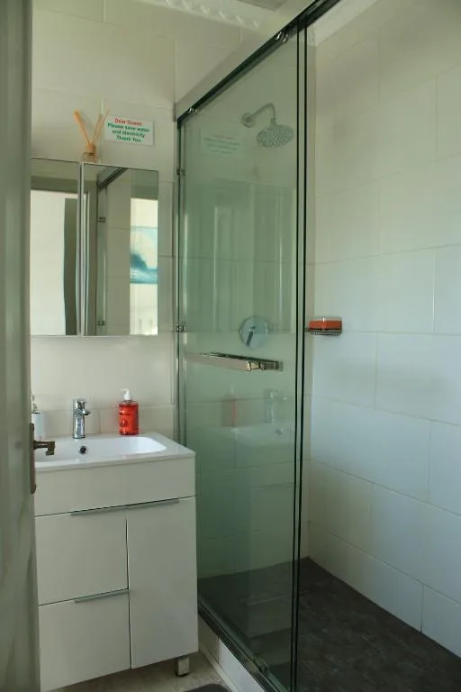 Modern bathroom with vanity sink, mirror, and glass shower enclosure