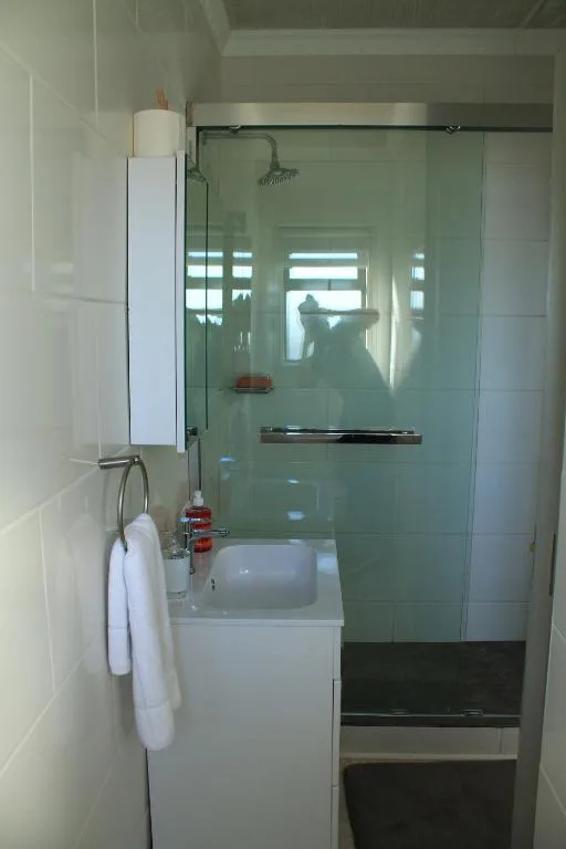 Modern bathroom with glass shower enclosure and white vanity