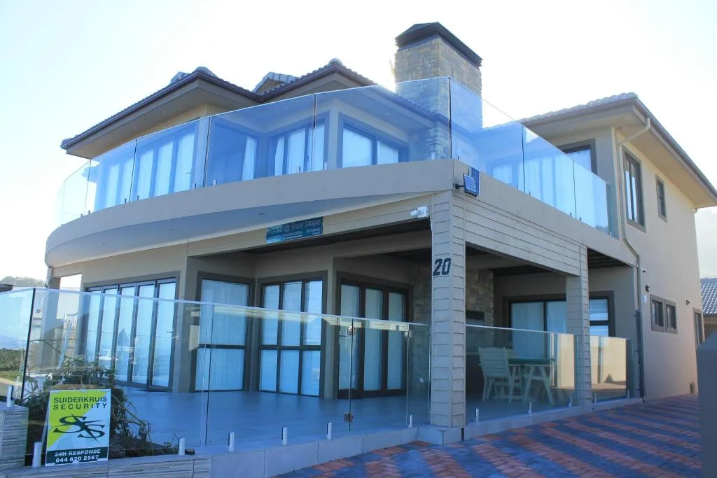 Modern multi-level beachfront property with glass balconies and brick paving