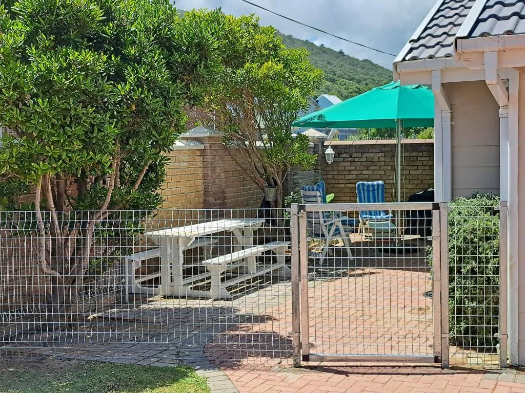 Shaded outdoor patio with turquoise umbrella and seating area