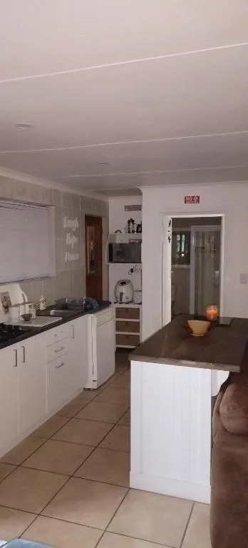 Open-plan kitchen with white cabinetry, island counter, and appliances