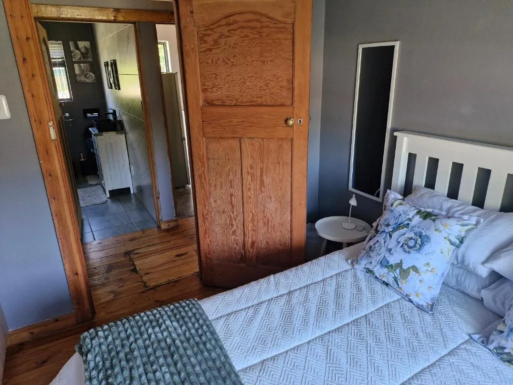Spacious bedroom with twin beds, wooden wardrobe, and ensuite access